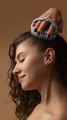 Fototapeta premium Woman massaging scalp with silicone brush enjoying relaxation and wellness. Concept of trichology, scalp care, home wellness, and social media content about beauty routine.