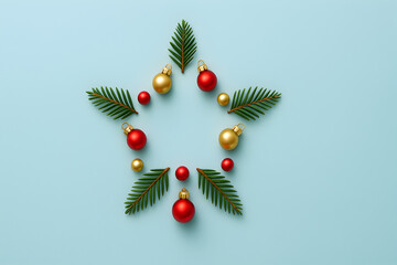 Festive christmas star made of fir branches and baubles on a light blue background for the holiday season, christmas