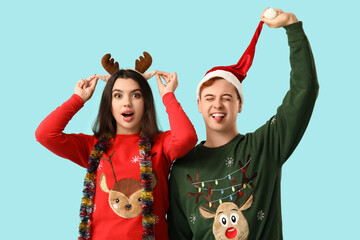 Young couple with Christmas tinsel on blue background