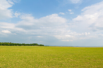 PASAK CHONLASIT DAM, LOPBURI, THAILAND Expansive green meadow and campground area next to the reservoir, a popular tourist destination and relaxation spot.