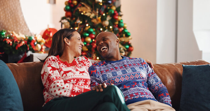 Christmas, sofa and interracial couple with laugh, tree and love in living room of house together. Joke, smile and man with woman, xmas and holiday or vacation bonding for festive season or tradition