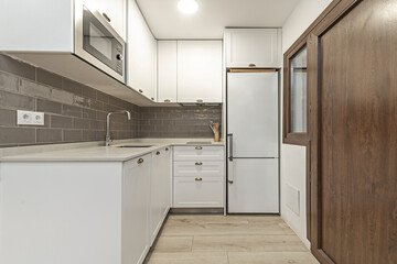 Composition of a modern kitchen with dark blue cabinet fronts and concave handles, including a storage system with internal organizers