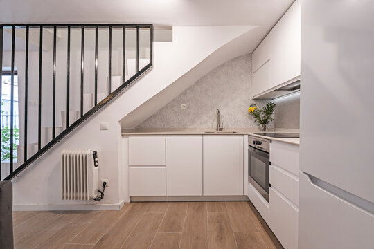 Side view of a corner kitchen with floor-to-ceiling cabinets and slim-profile appliances to maximize space in a small home