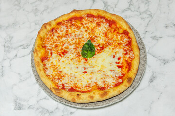 Drops of extra virgin olive oil glisten on the surface, enhancing the flavors of the basic ingredients of this Italian pizza