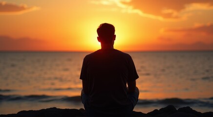 Man sitting on a rock looking out at the ocean