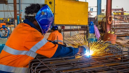 Welder at work Industrial construction with protective gear and sparks flying during a welding process