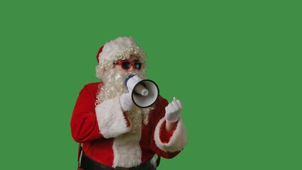 Santa Claus with a white curly beard, wearing a red suit and sunglasses, shouts into a megaphone against a green background. Ideal for Christmas themed compositions.