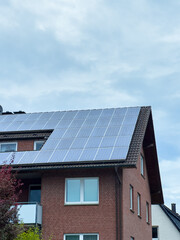 Fototapeta premium City home embraces renewable energy with solar panels under a bright, cloudy sky