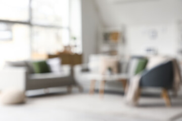 Stylish interior of living room with grey sofas and armchair, blurred view