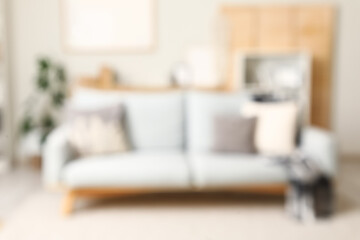 Modern interior of living room with stylish sofa, blurred view