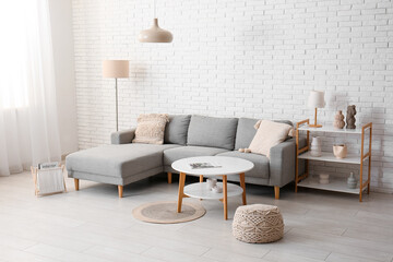 Stylish grey sofa with table and lamps in living room