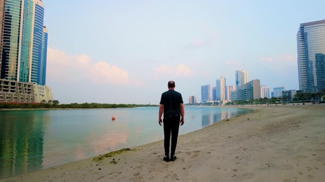 Elderly man engaged in slow Tai Chi on a serene urban beach. Tall skyscrapers in background under soft, diffused sunset light, creating a tranquil, contemplative ambiance.
