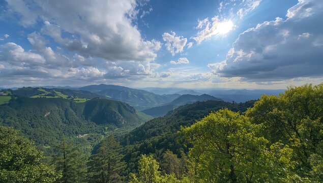 Expansive view of lush green mountain ridges beneath a picturesque blue and cloudy sky, showcasing seasonal change