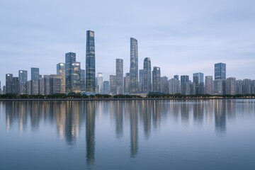 Fototapeta premium Urban Skyline Reflection at Dusk: Modern Cityscape of Skyscrapers with Calm Water in the Foreground