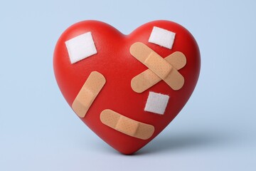Heart with bandages representing healing, recovery, and emotional support, conceptual healthcare illustration, studio shot