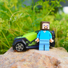 Naklejka premium Minecraft Steve figure with toy car on a rock in a natural setting
