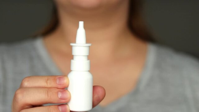 Close up of a female using nasal spray, relieving blocked and runny nose 