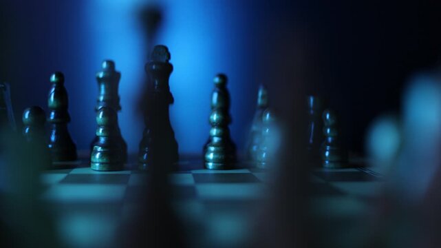 Animated chessboard rotating steadily with chess pieces arranged for play, representing the classic battle between dark and light pieces in intellectual competition, Semi-darkness and blue backlight