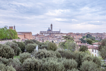 Obraz premium Ancient stone cityscape with lush greenery and historical architecture, showcasing a captivating landscape view that invites exploration and travel experiences