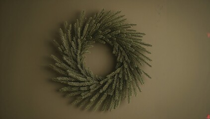 Naklejka premium On an olive colored wall, a circular wreath crafted from fir branches and needles, seasonal decor for Christmas