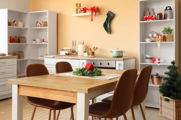 Interior of kitchen with Christmas tree, shelf units and dining table