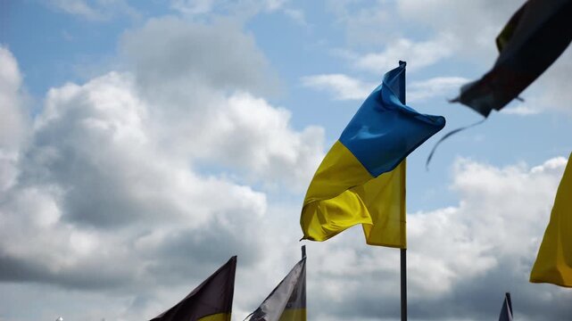 View on blue-yellow flags at countless graves of ukrainian soldiers alley of glory in Kharkiv. This site commemorates heroes and maintains the memory of wartime events in Ukraine. Slow moiton