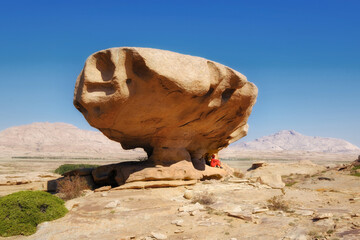 The stone mushroom is an amazing creation of nature in the Bektau Ata Nature Park in Kazakhstan - a giant boulder balancing on a thin leg in the middle of the steppe landscape 