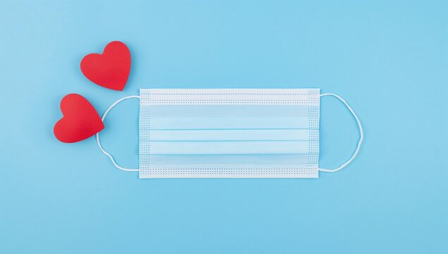 Two red hearts and a blue face mask on a blue background, appreciation for medical staff, World Health Day - Powered by Adobe