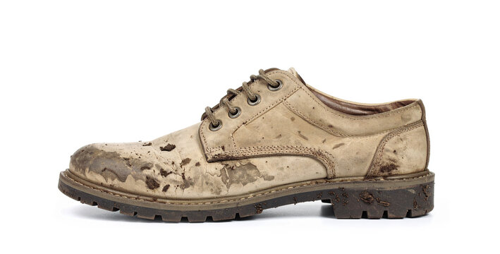 Dirty worn leather shoe covered in mud