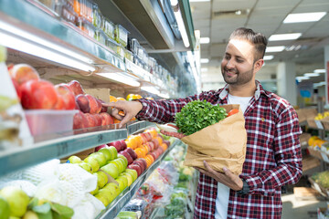 Indian man purchasing fruits and vegetables at super shop.