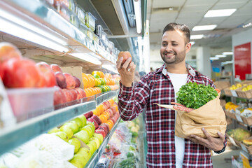 Indian man purchasing fruits and vegetables at super shop.