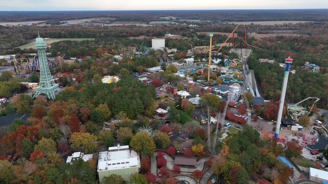 Aerial view of Kings Dominion Amusement Park and Water Park in Soak City, Virginia. Wide shot. Multicolored trees in fall season. Orbit wide shot.