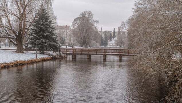 Candamia park in winter with snow covering the ground and a wooden bridge, highlighting seasonal change