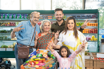 Indian family standing together at grocery shop.