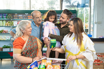 Indian family standing together at grocery shop.