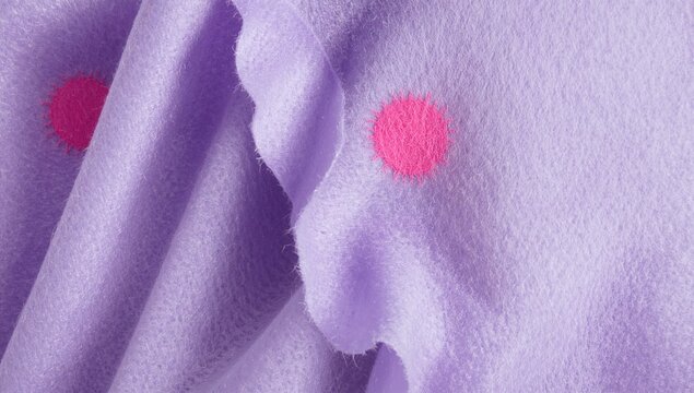 Closeup of woolen matt textile featuring a light purple background with pink felt spots, suitable for editorial header background