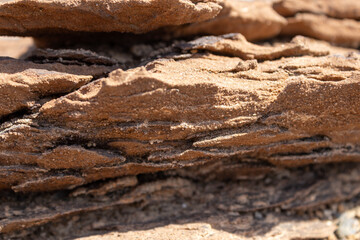 Natural background of reddish-brown sandstone formation with horizontal lines and deep grooves