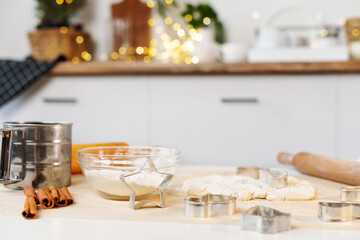 Christmas cooking. Flour, dough, cookie cutter to make Christmas gingerbread cookie on the table. Xmas baking at kitchen.