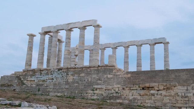 Greece Cape Sounion with ruins of ancient temple of Poseidon at sunset. Ancient Greek architecture. Tourist and travel landmark in Attica, Sounion, Greece