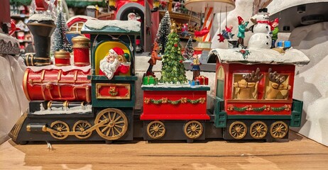 Figura de Santa Claus en una vieja locomotora de un tren con motivos navideños en el estante de un comercio