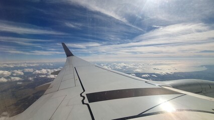 Obraz premium View from Airplane Window with Wing and Blue Sky