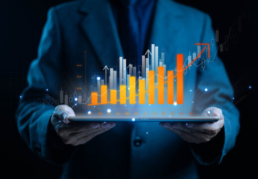 Businessman holding digital tablet with glowing bar graph and growth chart, representing business analytics, data visualization, financial success, and performance strategy. - Powered by Adobe