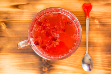 Homemade cranberry mors in transparent glass cup on rustic table. Organic berry drink rich in vitamins, healthy natural refreshment, detox and wellness concept. © Natallia Leanovich