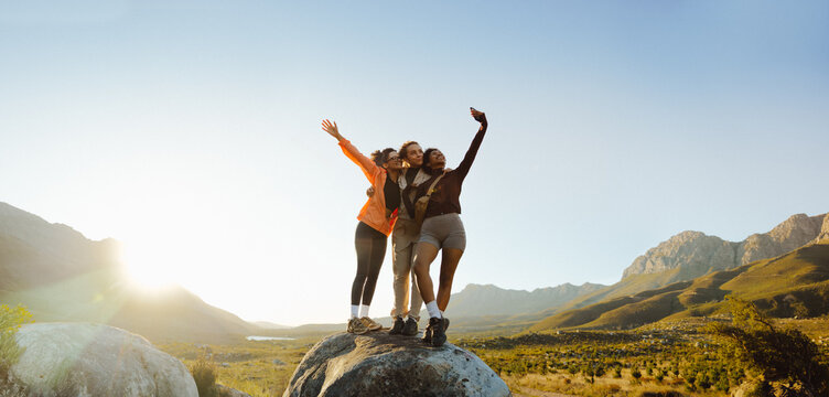 Friends taking a selfie atop a rock
