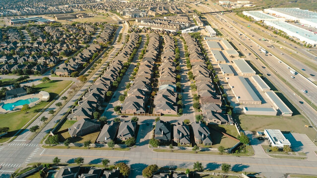 Community pool in upscale Castle Hills neighborhood row of uniform two-story homes. Immature landscaping, sound wall buffer separate from busy Highway 121 frontage, logistic hub, Lewisville, TX
