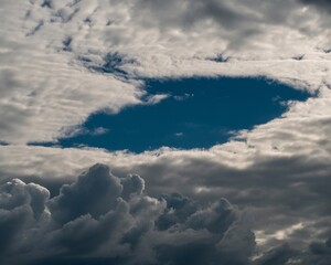 Dramatic sky with a vibrant blue opening amidst billowing clouds, suggesting hope and transition.