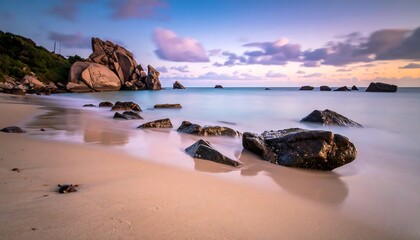 Serene coastal scene at dusk, with large rock formations on the shore, tranquil water, and colorful sky