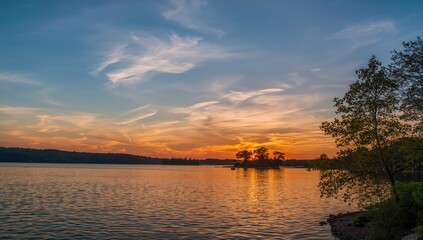 Fototapeta premium Lakeside sunset casting reflections on the water, evoking tranquility