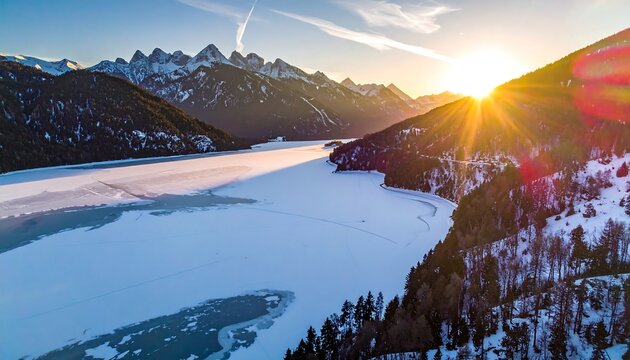 Snowy mountains frame an icy lake as the sun rises casting a warm glow across a picturesque landscape - Powered by Adobe
