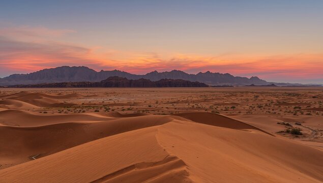 Dawn over the vast desert dunes and rocky peaks